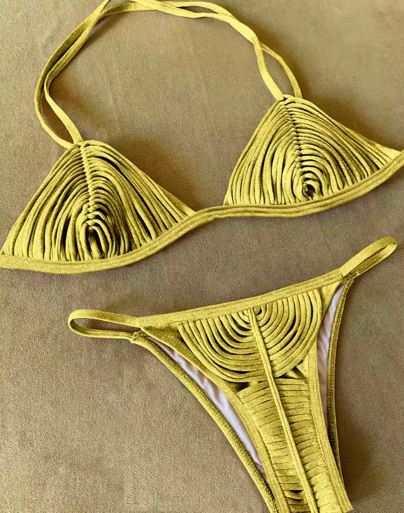 This image features a luxurious and vibrant gold bikini, perfect for making a statement at a resort. The bikini top is designed with a sexy bandage pattern and includes removable pads for a customizable fit.