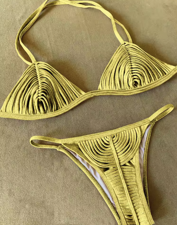 This image features a luxurious and vibrant gold bikini, perfect for making a statement at a resort. The bikini top is designed with a sexy bandage pattern and includes removable pads for a customizable fit.